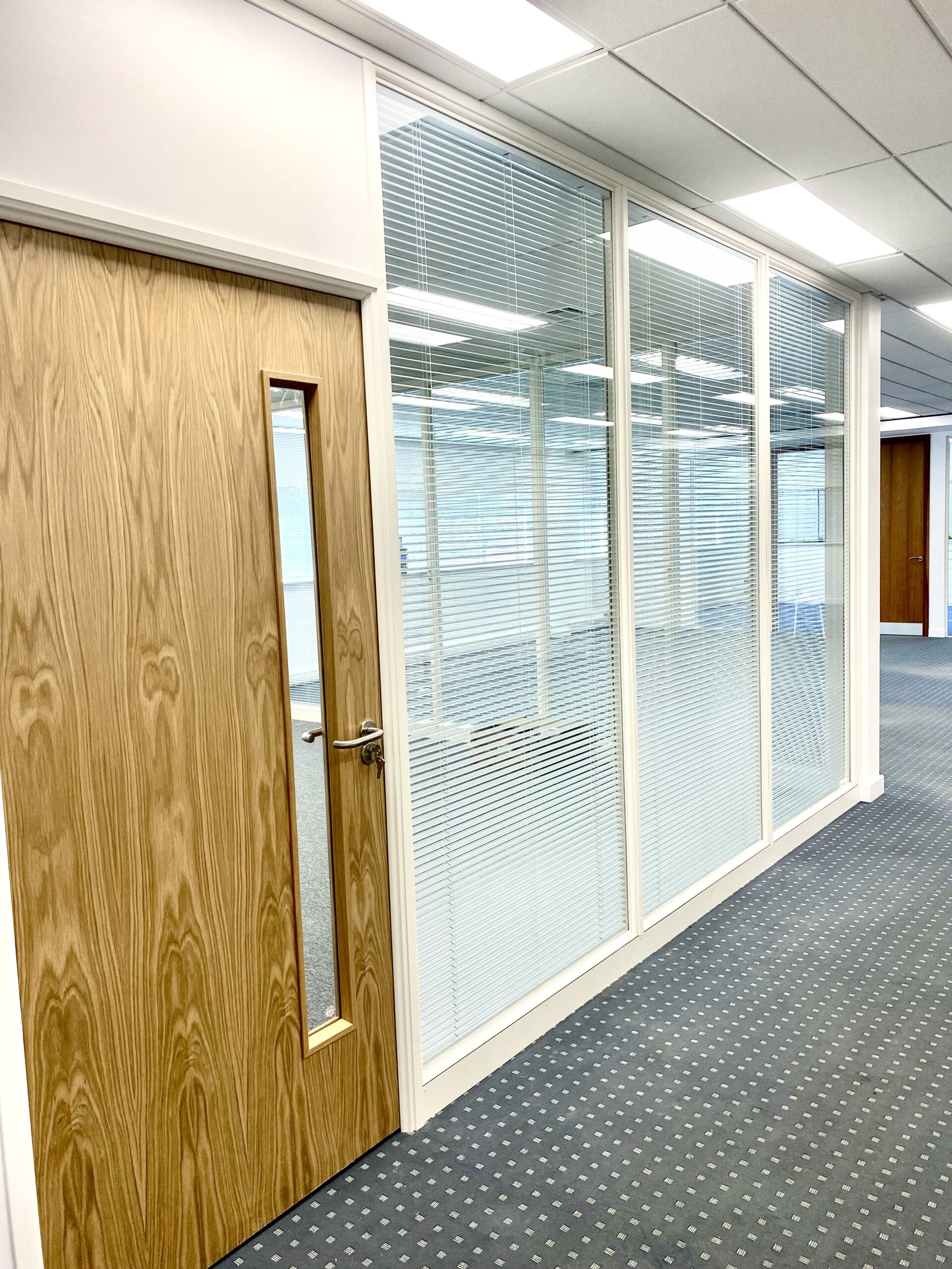 Double glazed partition with integral blinds and oak veneered door